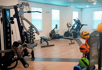 A gym with a variety of exercise equipment including treadmills, stationary bikes, and weight machines.